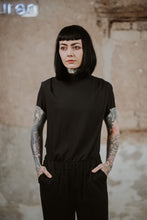 Lade das Bild in den Galerie-Viewer, Model mit kurzarmiger Bluse mit Stehkragen und offenen Kanten am Ärmelabschluss in schwarz