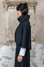 Lade das Bild in den Galerie-Viewer, Model mit schwarzer Kurzjacke mit Stehkragen, seitliche Ansicht