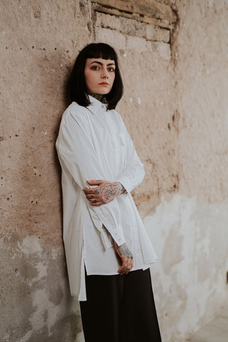 Model mit Longbluse in weiß mit aufgesetzter Tasche